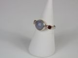 a close up of a ring with a blue stone on a white cone