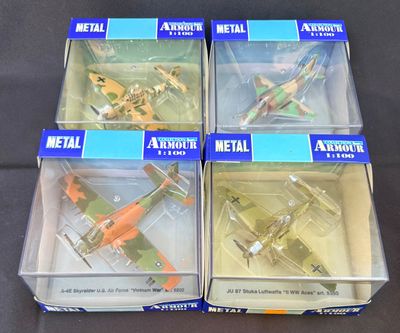 trois boîtes contenant un assortiment de maquettes d'avions en métal, posées sur une table