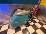 a blue machine that is sitting on a checkered floor