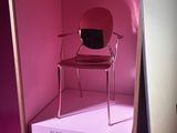 a red chair in a pink box with a pink background