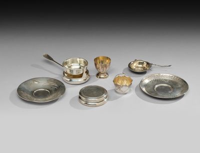 un ensemble d'assiettes et de cuillères en métal argenté posées sur une table