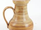 a brown vase that is sitting on a white surface