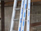several ladders are leaning against a wall in a warehouse
