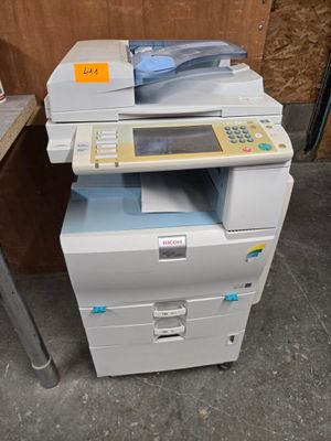 une imprimante posée sur un bureau, à côté d'une chaise