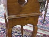 a small wooden table with a mirror on top of it