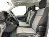 the interior of a white van with grey seats and a steering wheel