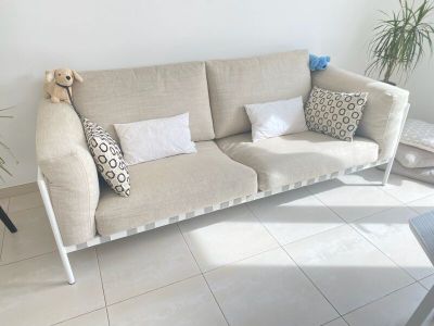 un canapé avec des coussins et un ours en peluche posé dessus