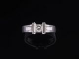 une bague en or blanc sertie d'un diamant sur fond noir