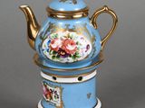 a blue and gold tea pot with flowers on it