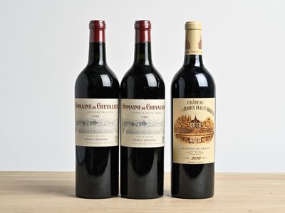 trois bouteilles de vin posées sur une table en bois