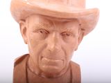 statue of an old man with a hat on a white background