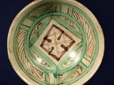 a green and white bowl with a design on it
