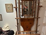a wooden rack with a mirror and a hat on it
