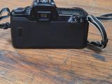 a black camera on a wooden table with a black strap