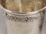 a close up of a silver cup on a white surface