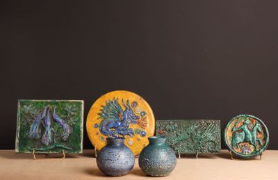 trois vases posés sur une table à côté d'une assiette