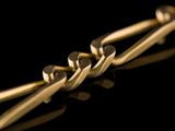 a close up of a gold chain on a black surface