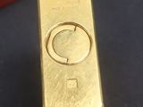 a gold bar sitting on a table next to a red box
