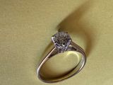 une bague en diamant posée sur une surface jaune