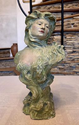 a statue of a woman holding a flower on a table