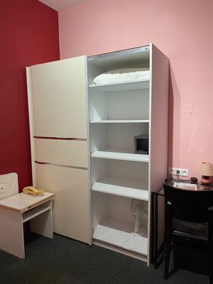 an image of a small room with a desk and a bookcase