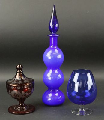trois vases en verre de couleurs différentes posés les uns à côté des autres sur une table