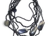 un gros plan sur un collier composé de perles noires et de perles noires