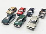 several toy cars are lined up in a row on a white surface