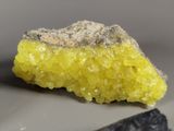 a piece of rock that has yellow crystals on it