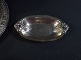 a silver plate and a silver bowl on a black table