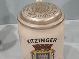 a beer canister sitting on a table next to a cup