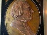 a plaque of a man that is hanging on the wall