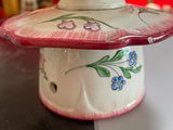a white and red vase with flowers on it on a table