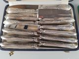silverware in a case on a table next to a knife and fork