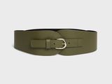 une femme portant une ceinture en cuir verte avec une boucle dorée