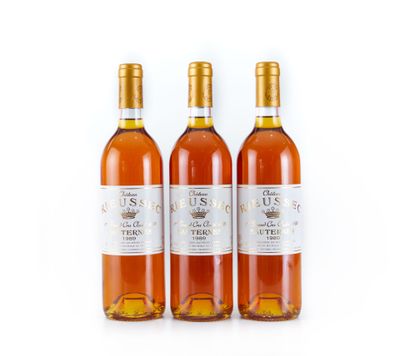 trois bouteilles de vin posées les unes à côté des autres sur une surface blanche
