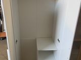 a white cupboard with shelves and a shelf in the corner