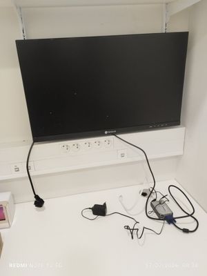 a flat screen tv mounted on a wall above a desk