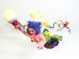 une sculpture représentant un clown avec un ballon et d'autres objets