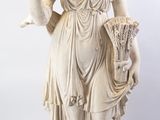 marble statue of a woman holding a bird and a vase