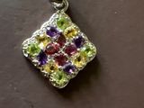 un gros plan d'un pendentif orné de pierres multicolores sur un fond marron