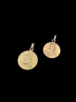 une paire de boucles d'oreilles en forme de pièces d'or sur lesquelles est représentée une femme