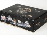 une petite boîte noire ornée d'un motif floral