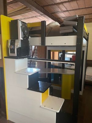 un lit superposé avec un escalier et un micro-ondes posé dessus