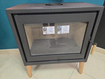 un petit poêle avec une porte vitrée dans une pièce