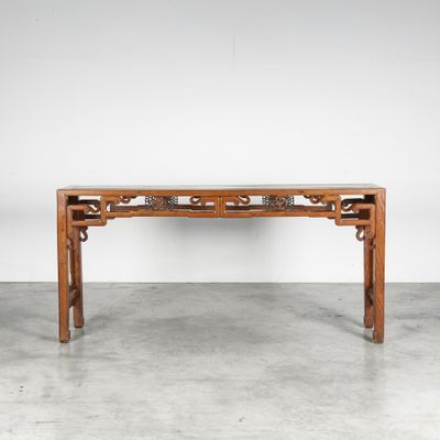 une table en bois dont le plateau est orné d'un motif sculpté