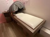un lit sur lequel est posé un oreiller, dans une chambre