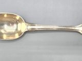 an antique silver spoon with a flower decoration on the handle