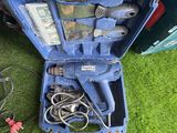 une boîte à outils bleue contenant des outils, posée sur l'herbe