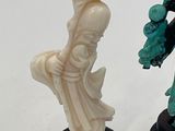 two figurines of a man and a woman standing on a pedestal